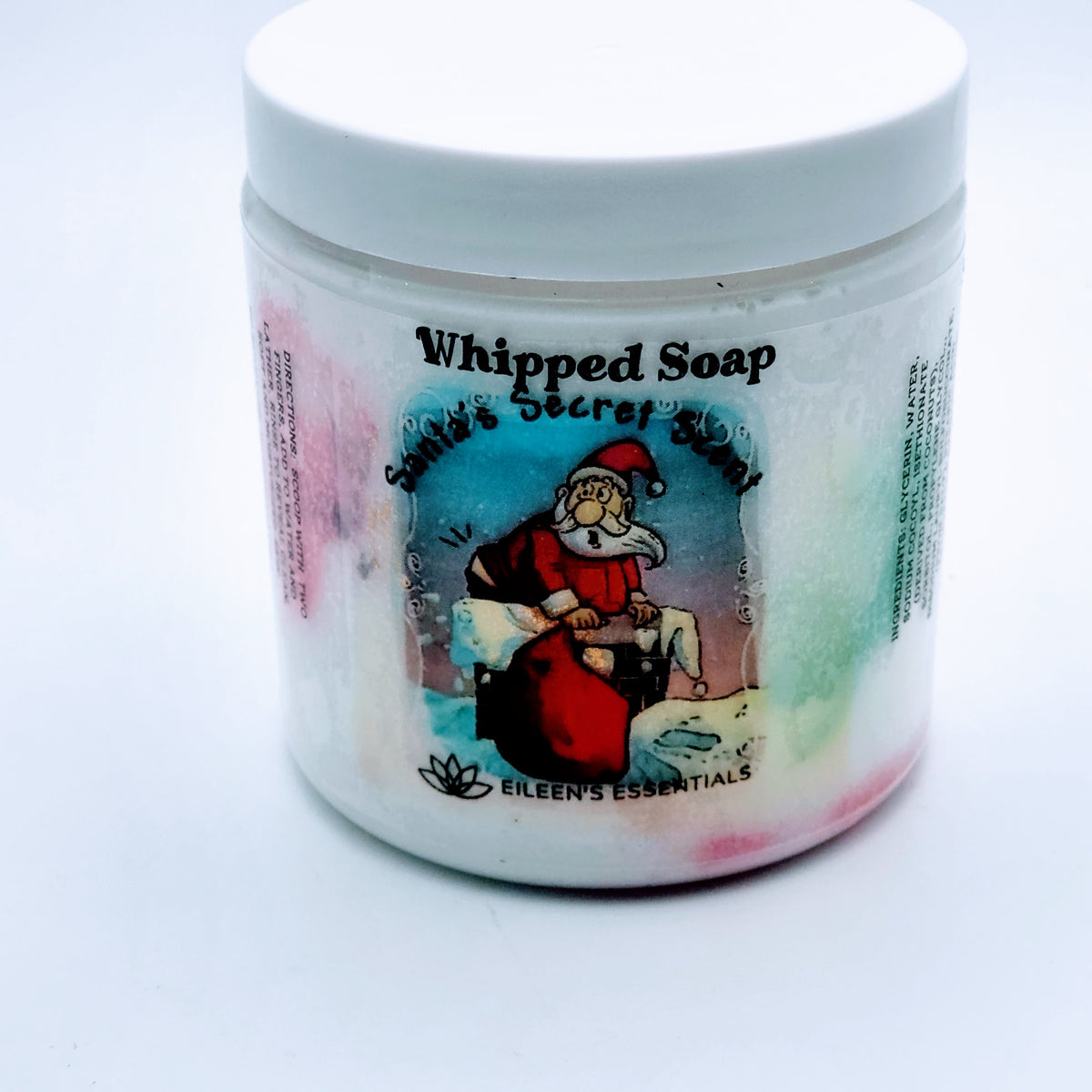 “Santa's Secret Scent whipped soap jar with a white lid, Santa label, and colorful soap.”