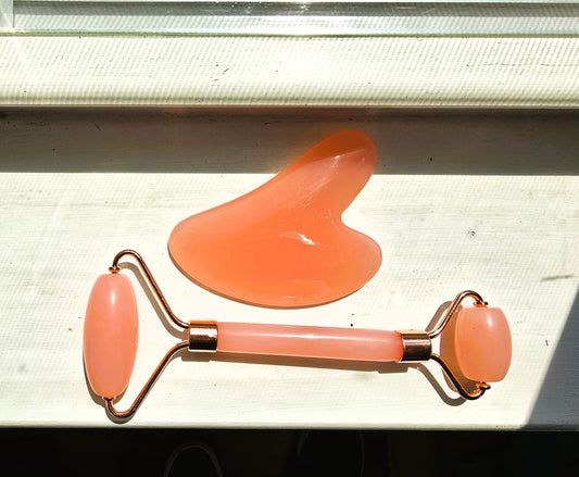 rose-quartz facial roller and gua sha tool to reduce facial inflammation.